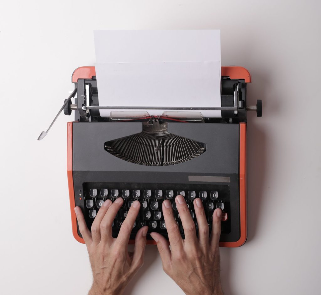 Unas manos usando una máquina de escribir para redactar las diferencias entre la localización y la traducción.