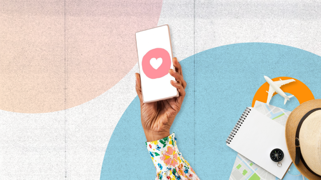 Hand holding a phone with a heart icon, symbolizing customer engagement. Surrounding items—a notebook, map, compass, hat, and airplane model—represent key elements of an essential travel agency marketing strategy